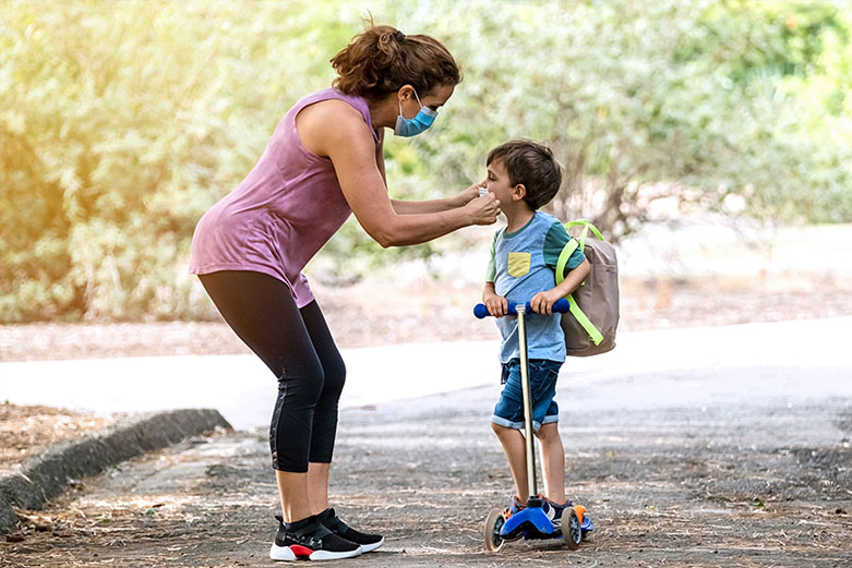 mom with son on scooter in masks