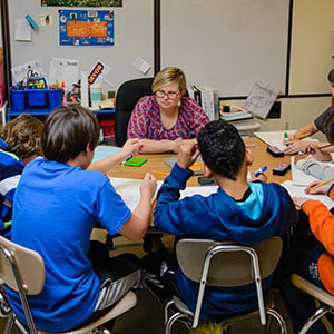 teacher with students at table