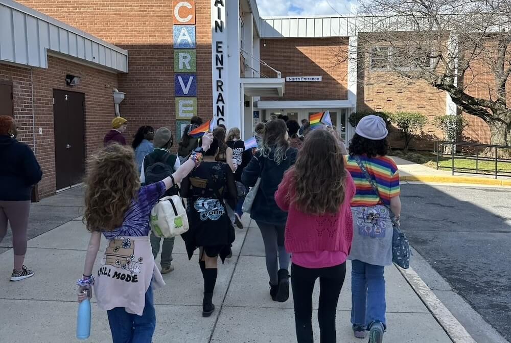 A large group of students smile for a photo during lunch