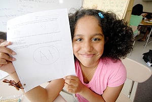 Middle school student holding up A+ paper