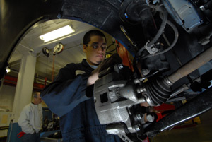 Student inspects vehicle brakes