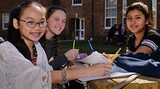 girls doing school work outdoors